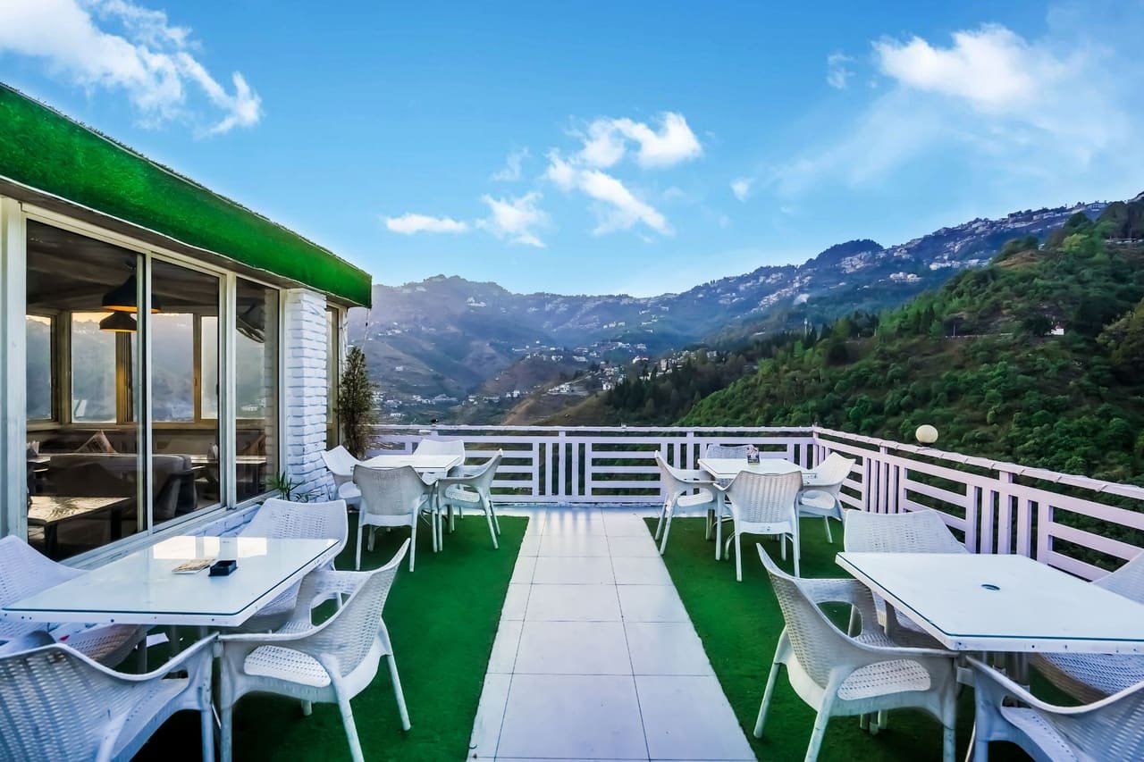 Terrace railing with the layered ridgelines of the Doon valley behind